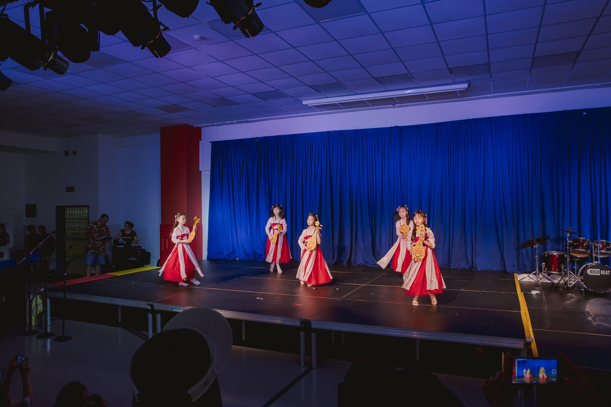 girls in costumes with lutes on stage