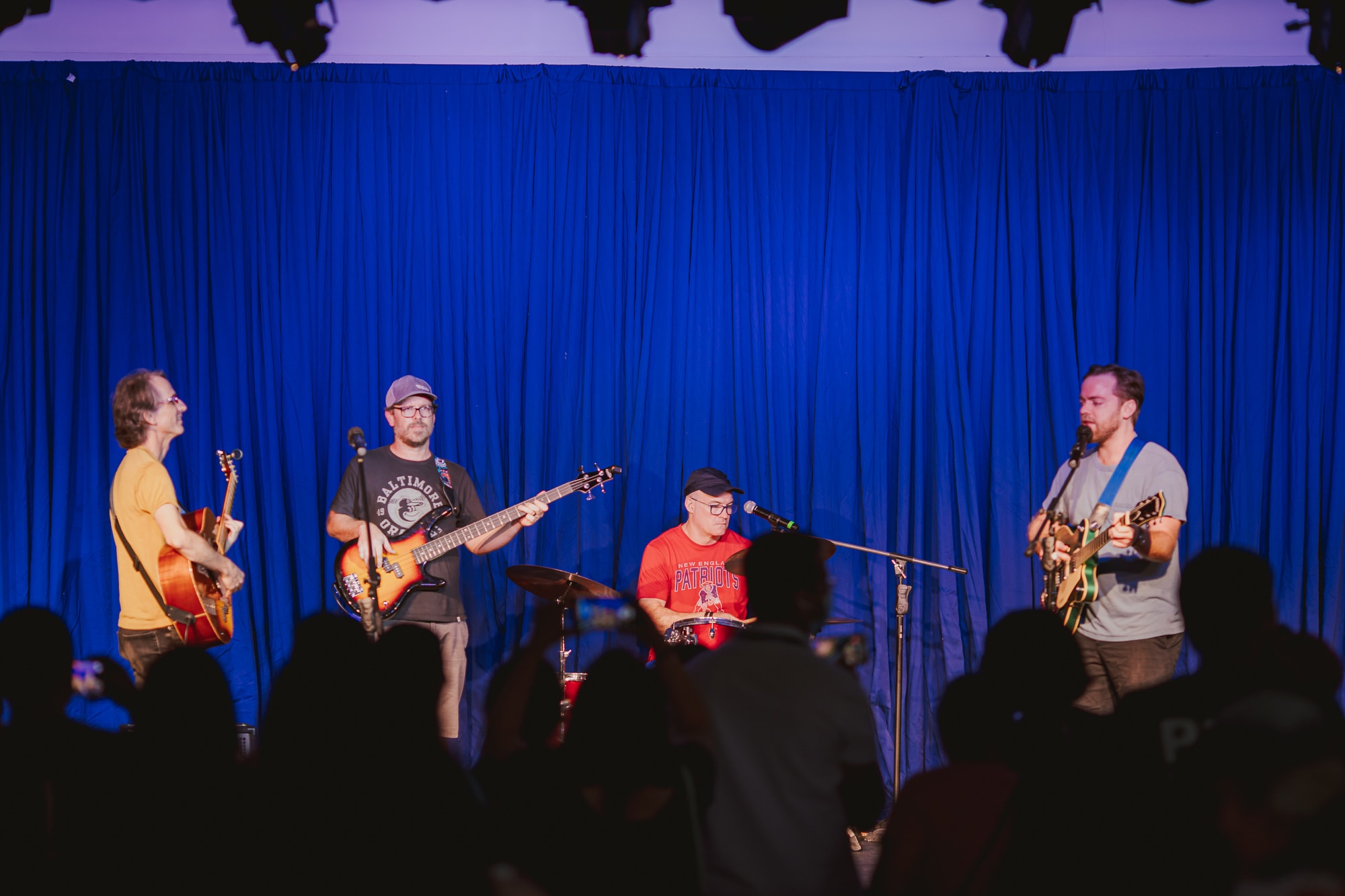men on stage with instruments performing in a band