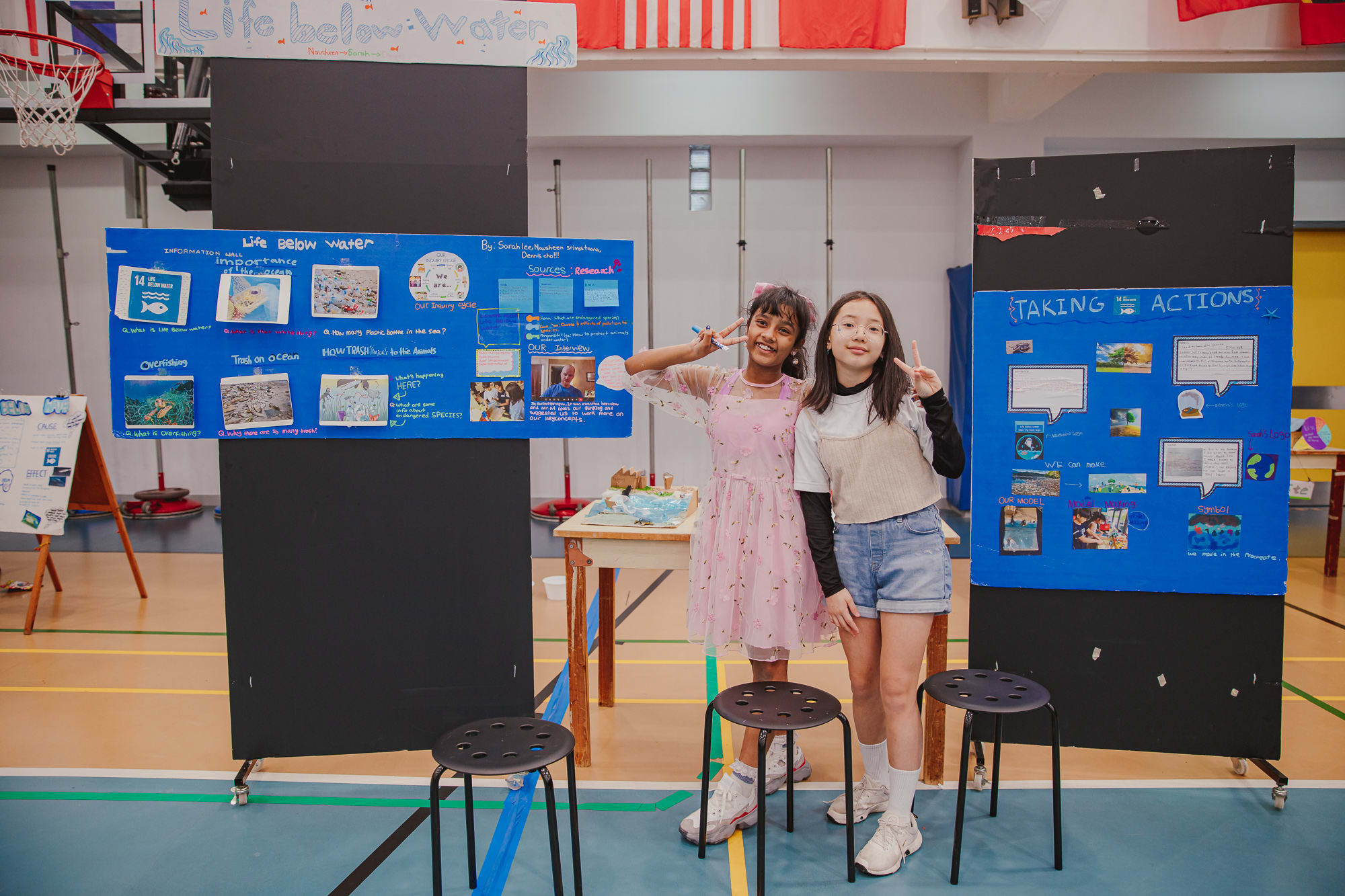 AISG PYP Exhibition with 2 students with their Life Below Water presentation boards