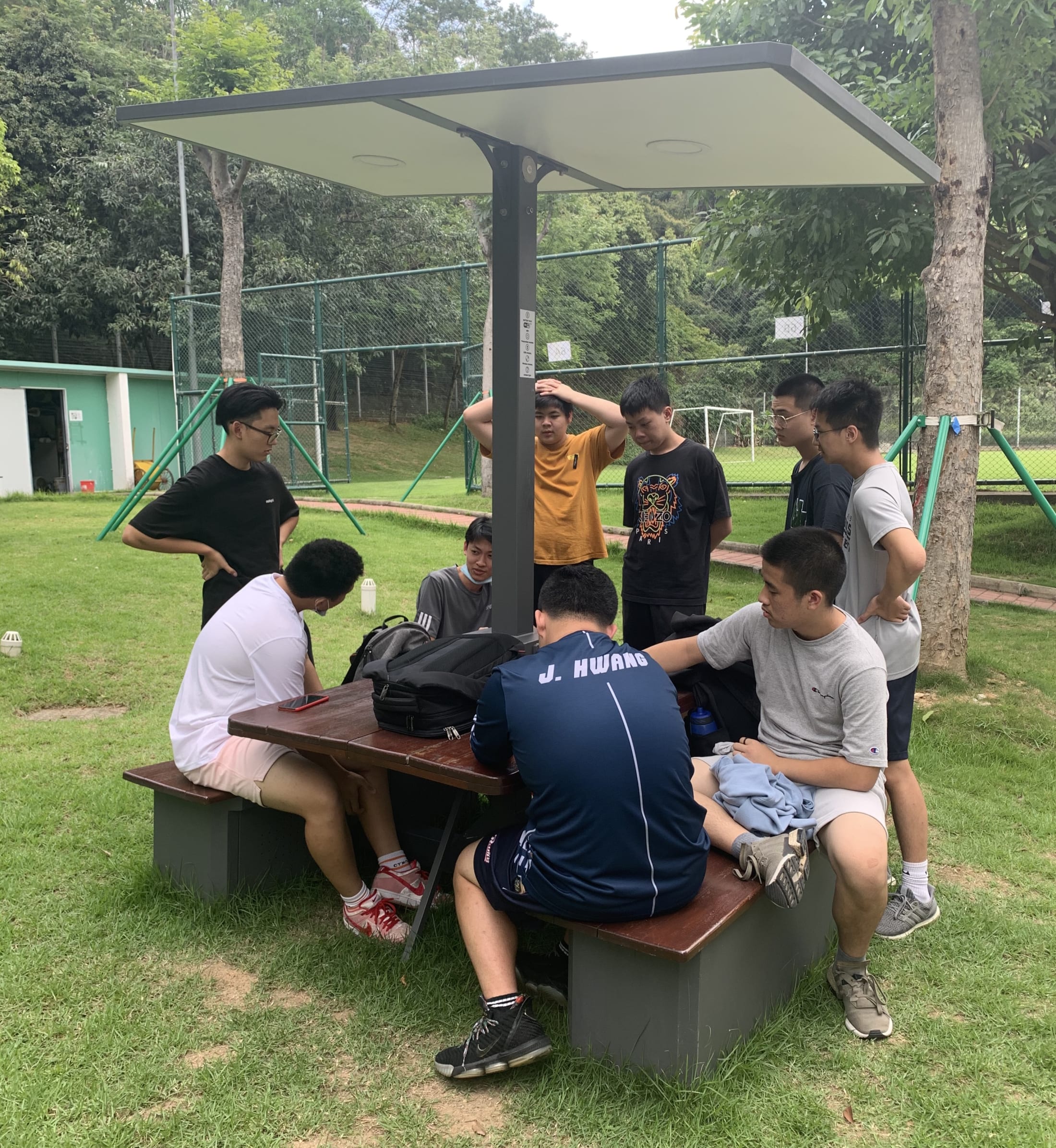 boys crowded around a picnic table