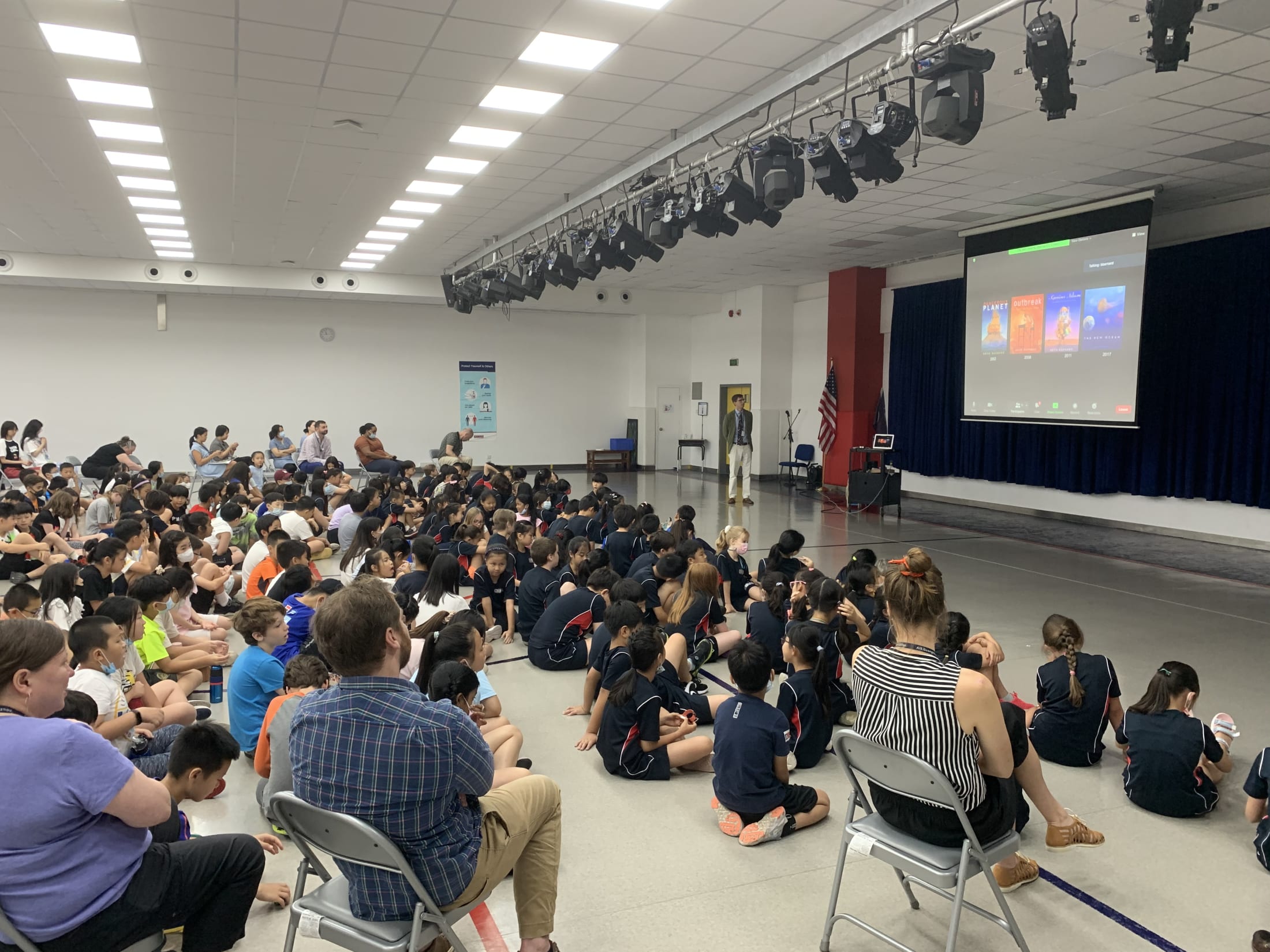 crowd of children watching presentation on screen