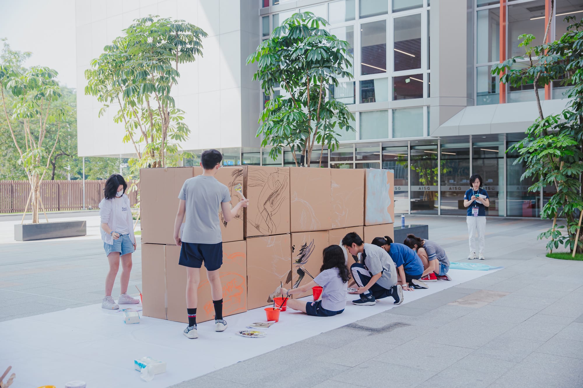 students starting to paint on cardboard boxes