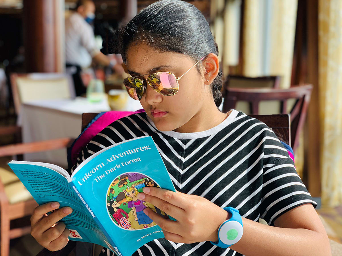 A girl is sitting and reading her book
